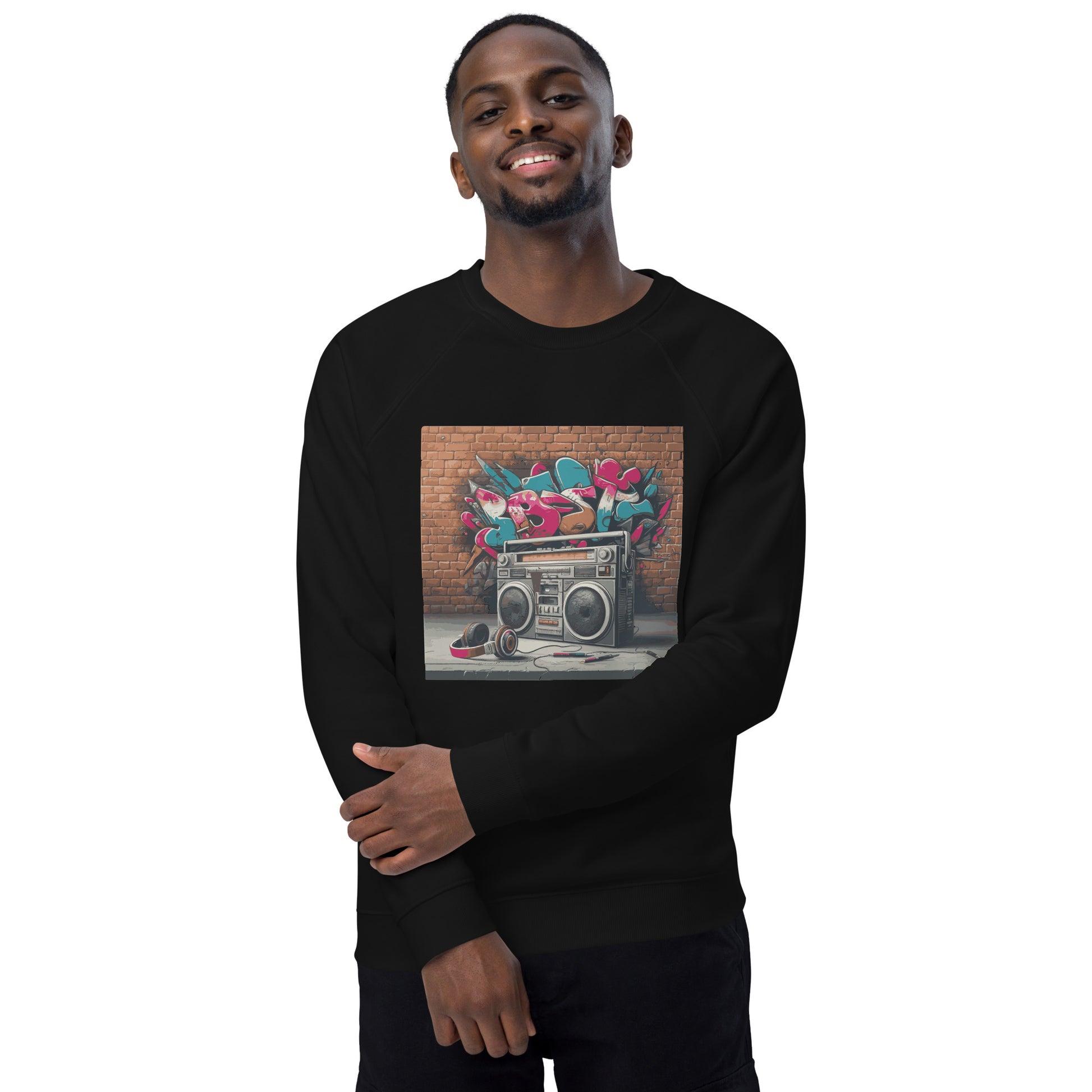 Model trägt gerne einen Unisex-Bio-Raglan-Pullover mit Boombox-Design. Schwarze Farbe