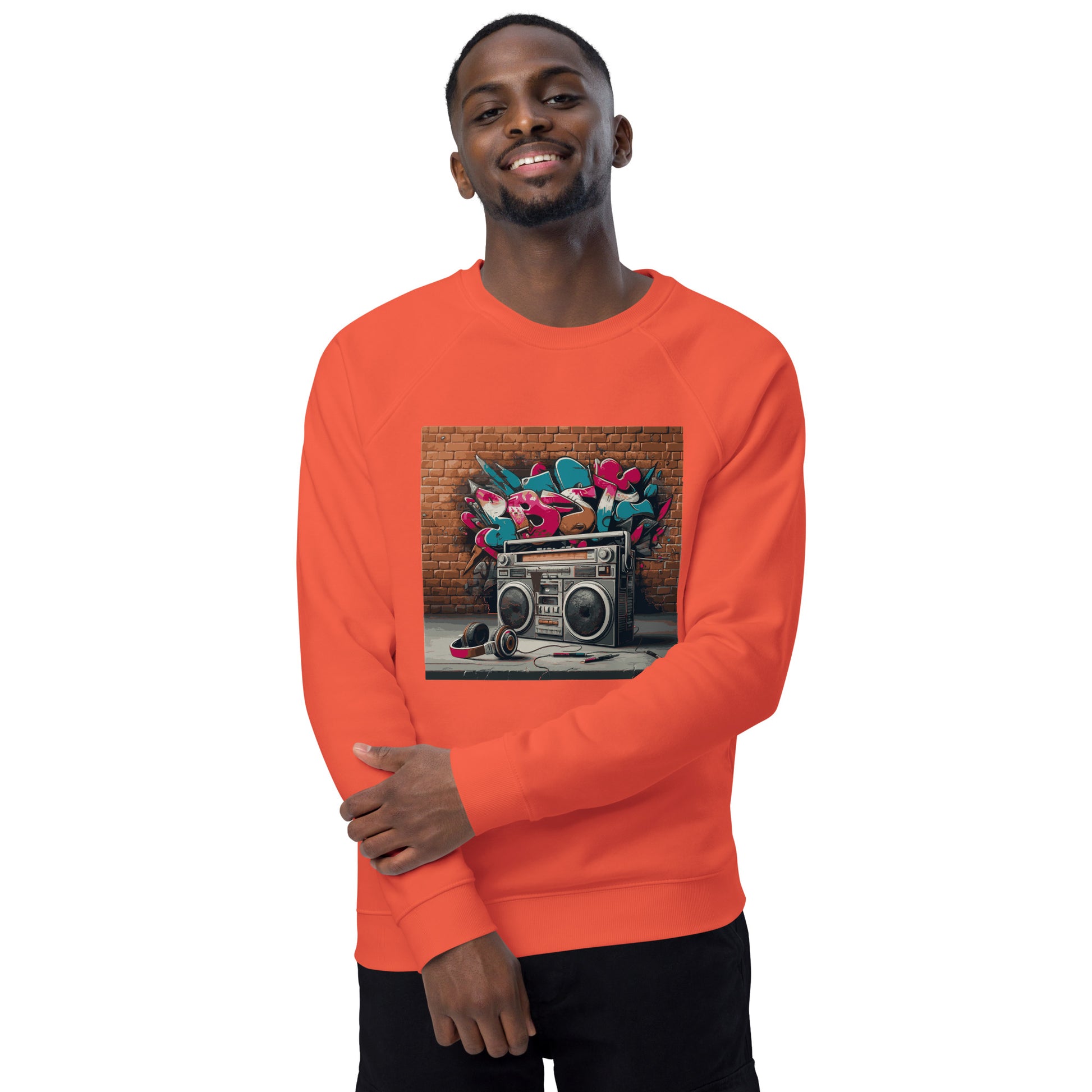 Model trägt gerne einen Unisex-Bio-Raglan-Pullover mit Boombox-Design. Gebrannte Orange Farbe