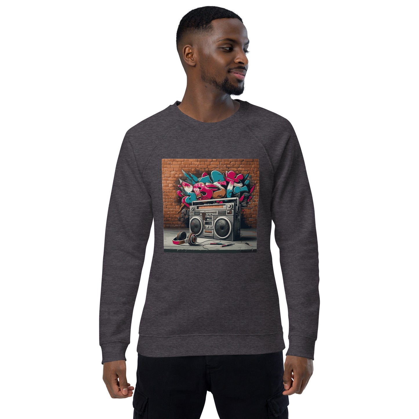 Männliches Model trägt Unisex-Bio-Raglan-Pullover mit Boombox-Design. Charcoal Melange Farbe