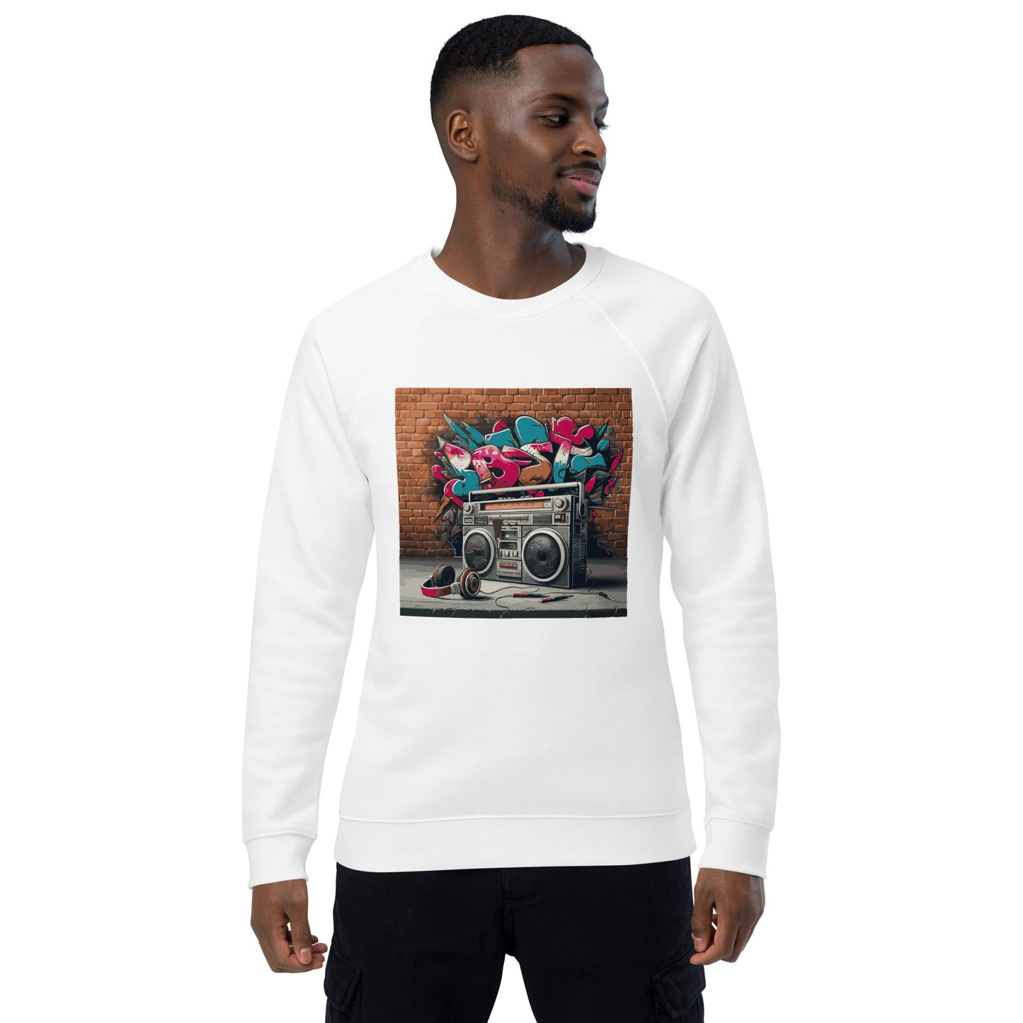 Männliches Model trägt Unisex-Bio-Raglan-Pullover mit Boombox-Design. Weiße Farbe